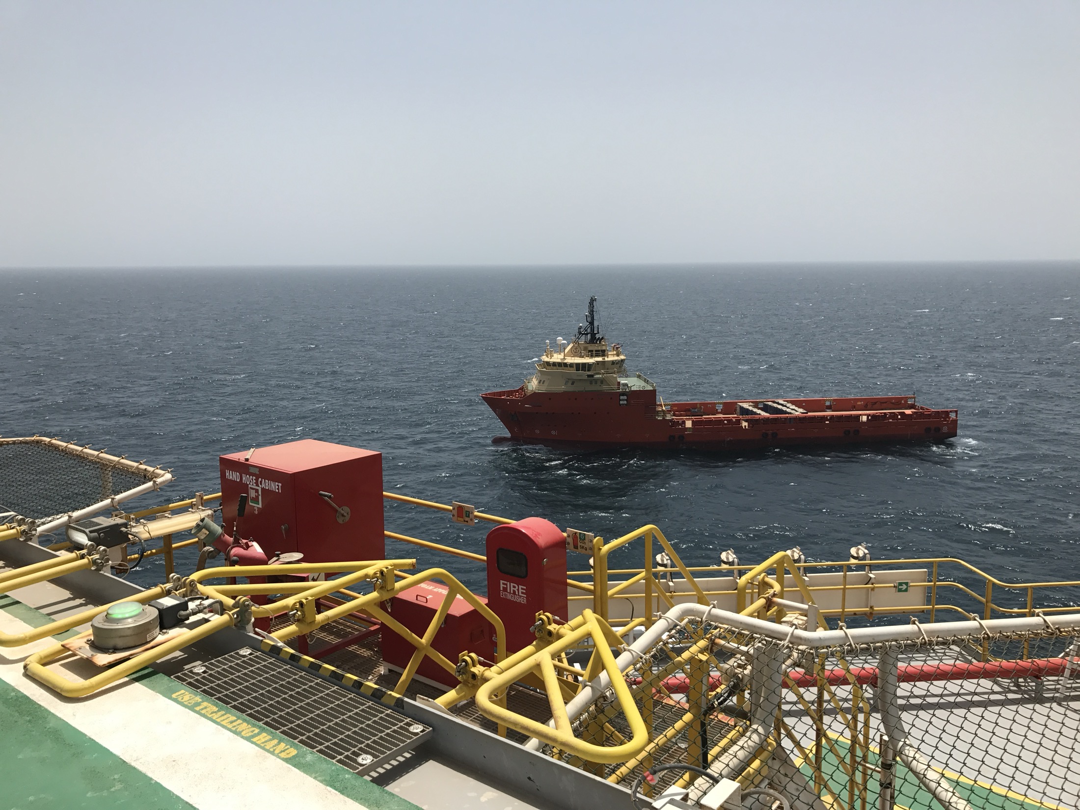Supply vessel viewed from an offshore platform during live operations.